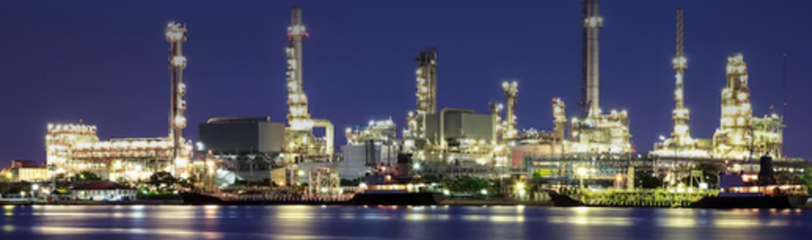 Industrial plant lit up at night along the water